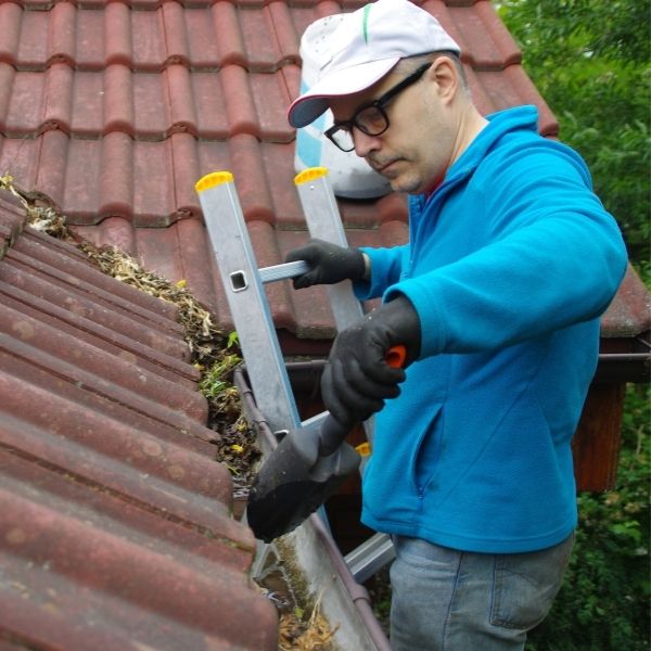 Roofing Guys Gold Coast performing gutter cleaning, clearing blockages and debris to protect homes from overflow and water damage.