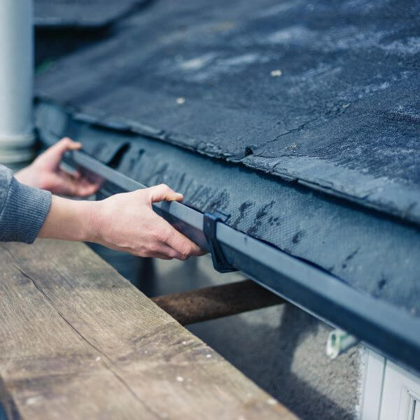 Roofing Guys Gold Coast technician repairing a residential gutter to fix drainage issues and prevent water damage.